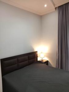 1 dormitorio con cama y lámpara junto a una ventana en Apartment Face en Batumi