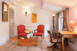 - un salon avec deux chaises rouges et un bureau dans l'établissement Hostellerie De L'abbaye De La Celle - Teritoria, à La Celle