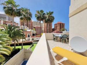 balkon z żółtą ławką i palmami w obiekcie California Sweet Home w Puerto de la Cruz