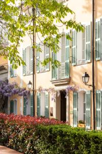a building with green shutters and flowers in front of it at Hostellerie De L'abbaye De La Celle - Teritoria in La Celle