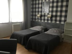 a bedroom with two beds and a checkered wall at OW Delta in Rewal +54 photos