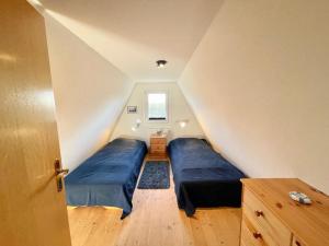a attic room with two beds and a window at Finnhütten Mönchgut Finnhütte 67 in Gager