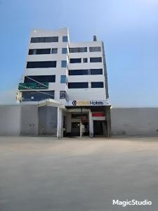 un gran edificio blanco con un cartel delante en Click Hotel by Suba, Jamnagar, en Jamnagar
