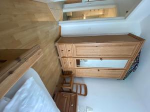 a room with a bed and a wooden dresser at Das Landhaus am Haff LHH B09 in Stolpe