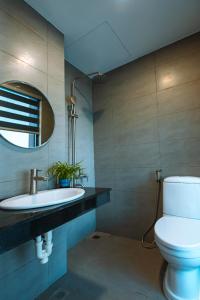 een badkamer met een toilet, een wastafel en een spiegel bij Khách Sạn Ngọc Hoa in Thăng Bình