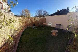 un pequeño patio con 2 sillas y una pared en L'aigrette moderne, ensoleillé et bien placé, en Thury-Harcourt