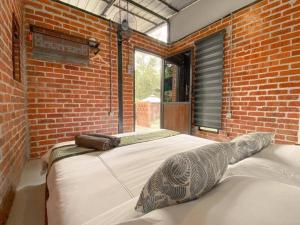 1 dormitorio con 1 cama grande en una pared de ladrillo en Tingkat Valley en Ipoh