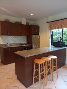 a kitchen with a counter and stools at a island at AG Property in Mae Pim