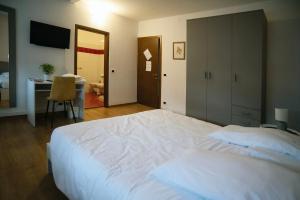 1 dormitorio con 1 cama blanca grande y escritorio en Albergo Alla Cesa, en Feltre
