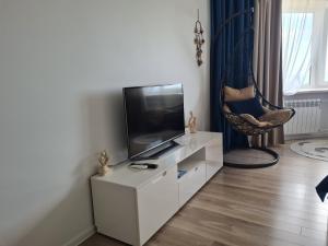 a living room with a tv and a chair at Baltic Sunset Apartments in Sillamäe