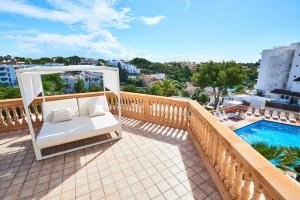 uma varanda com um baloiço e uma piscina em Apartamentos Azul Playa em Cala d´Or