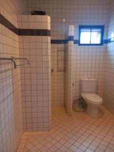 a bathroom with a toilet and a window at AG Property in Mae Pim