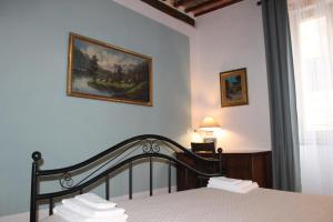 um quarto com uma cama e um quadro na parede em Il Girasole Storico em Pitigliano