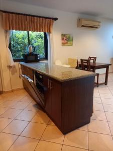 a kitchen with a counter and a dining room with a table at AG Property in Mae Pim