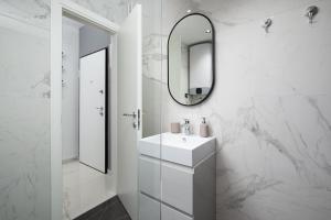 a white bathroom with a sink and a mirror at Sena Luxury Apartments in Pula +29 photos