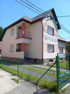 a house with a fence in front of it at Dům u splavu in Karolinka