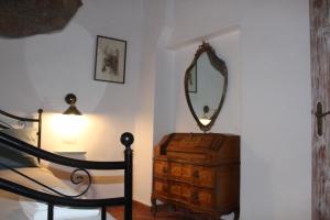 a bedroom with a mirror on top of a dresser at Il Girasole Storico in Pitigliano
