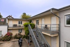 een appartementencomplex met een trap naar een balkon bij Penzion Rodos - Café in Praag
