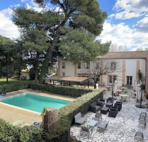 einen Pool mit Liegestühlen neben einem Haus in der Unterkunft Le Clos De L'aube Rouge - Montpellier / Castelnau le Lez in Castelnau-le-Lez