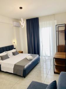 a bedroom with a large bed and a large window at Maor Hotel in Vlorë