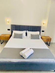 a large bed with two towels on it at Maor Hotel in Vlorë