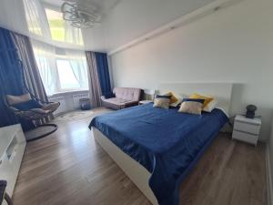 a bedroom with a large bed with a blue blanket at Baltic Sunset Apartments in Sillamäe