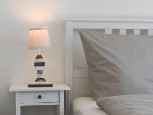 a lamp on a night stand next to a bed at Mein-Ostseeplätzchen Haus am Meer 8 in Niesgrau