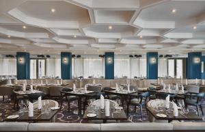 Ensana Buxton Crescent في بكستون: غرفة طعام كبيرة مع طاولات وكراسي