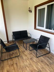 um quarto com duas cadeiras e um banco e uma janela em Vila Phoenix em Călimăneşti