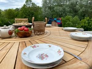 una mesa de madera con platos y cuencos de comida. en Le Sanglier Sauvage, en Bussières-lès-Belmont