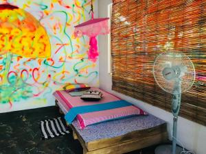 a room with a bed and a fan and a wall at Sigiriya Homestay in Sigiriya