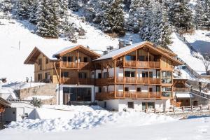 a lodge in the snow with snow covered premises at Villa Solinda App Puccini in Selva di Val Gardena