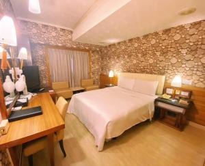 a hotel room with a large bed and a desk at 種子商旅 in Kaohsiung