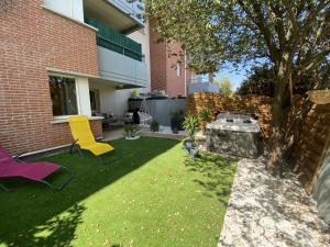 a backyard with two chairs and a fire pit at Le Jungle : T2 avec jardin et jacuzzi in Blagnac