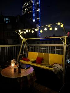 Big apartment with terrace & central location في باريس: أريكة على شرفة مع طاولة وأضواء