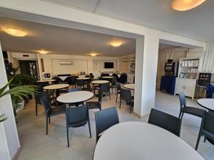 jadalnia ze stołami i krzesłami oraz kuchnia w obiekcie Hotel Verde Luna w mieście Cervia +30 zdjęć