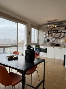eine Küche mit einem Tisch und Stühlen sowie eine Küche mit Aussicht in der Unterkunft Le Brooklyn - T2 à Compans avec vue remarquable in Toulouse