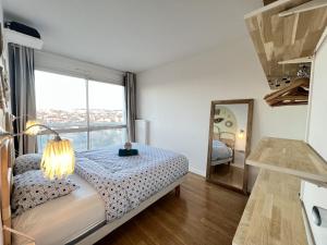 ein Schlafzimmer mit einem Bett und einem großen Fenster in der Unterkunft Le Brooklyn - T2 à Compans avec vue remarquable in Toulouse