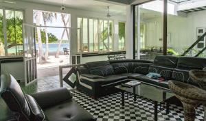 a living room with a couch and chairs and a table at Dhonfulhafi Beach View in Maalhos