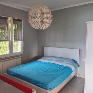 - une chambre dotée d'un lit avec des draps bleus et un lustre dans l'établissement Civico 25, Carcioni - Belgirate, à Belgirate