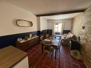 - un salon avec une table et un canapé dans l'établissement Le Saint Cyp - Briques et Charme à Toulouse, à Toulouse