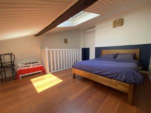 sypialnia z łóżkiem i drewnianą podłogą w obiekcie Le Saint Cyp - Briques et Charme à Toulouse w Tuluzie
