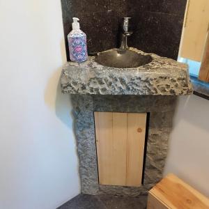 a stone bathroom with a sink and a door at le chalet des remparts in Aywaille +54 photos