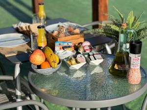 una mesa con fruta y botellas de vino. en VALTISYA POOL AND AIRPORT, en Telde