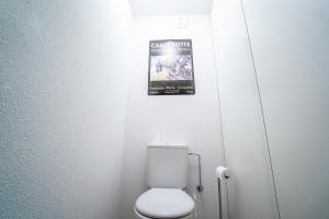 ein Bad mit einem WC und einem Plakat an der Wand in der Unterkunft Chalet récent cœur station in Thollon