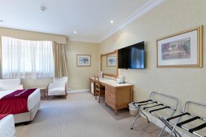 um quarto de hotel com uma cama e uma secretária em European Hotel em Perth