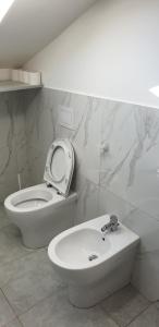 bagno bianco con servizi igienici e lavandino di Le Acacie rooms - ex B&B a Termoli