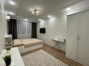 Un dormitorio pequeño con una cama y un televisor. en Nova Center, en Astana
