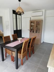 uma sala de jantar com uma mesa preta e cadeiras em Charmante Maison neuve au Lac d'Hourtin em Hourtin