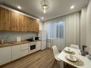 Una cocina con una mesa y un refrigerador blanco. en Nova Center, en Astana 14 fotos más